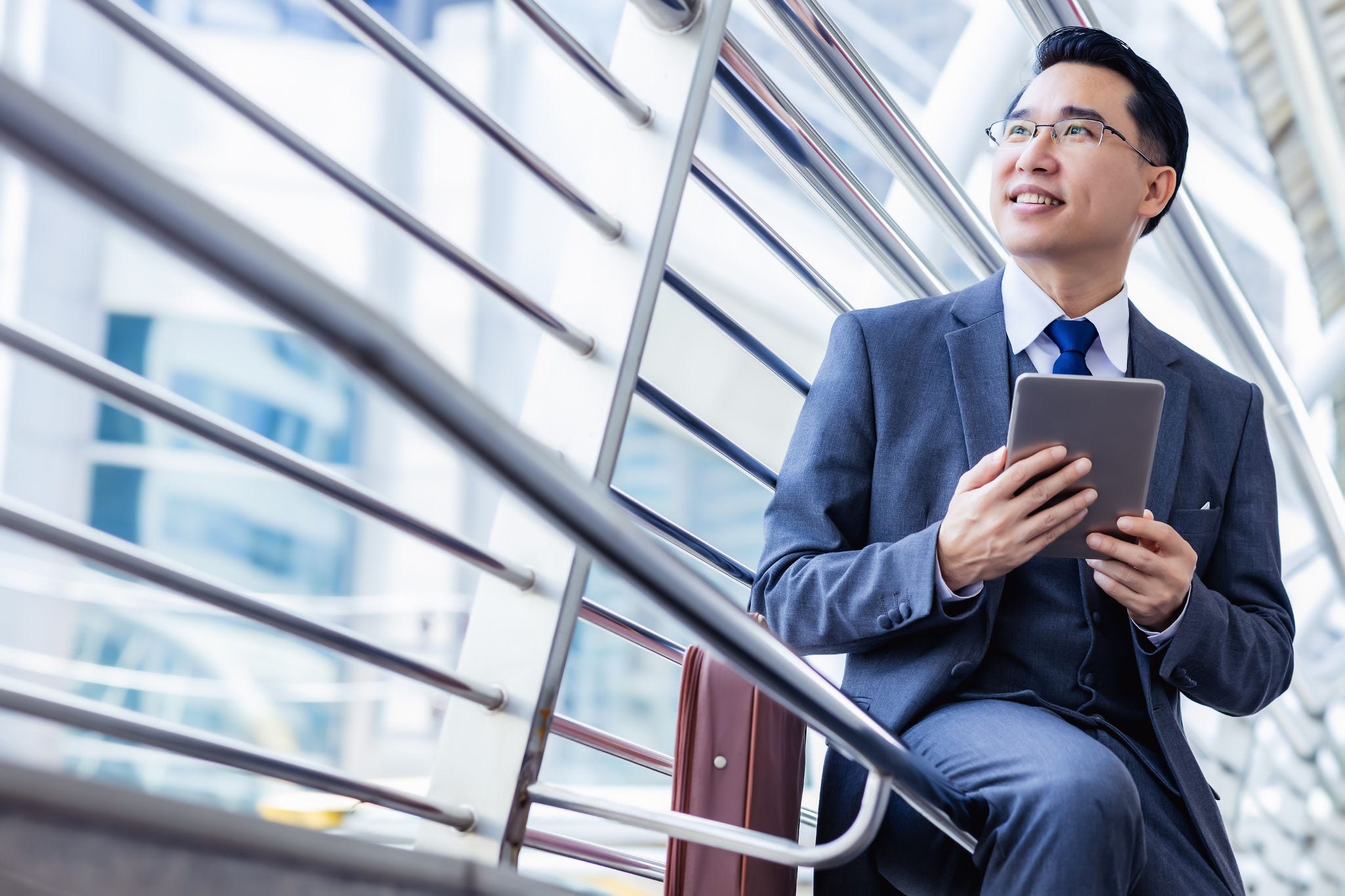 Handsome asian businessman holding digital tablet, wear suit and eyeglasses. Leadership executive business guy get successful of business. Male get confidence. Professional businessman portrait