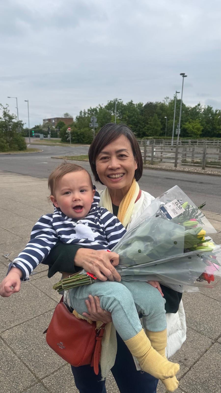 Gan Kwee Lian carrying grandchild