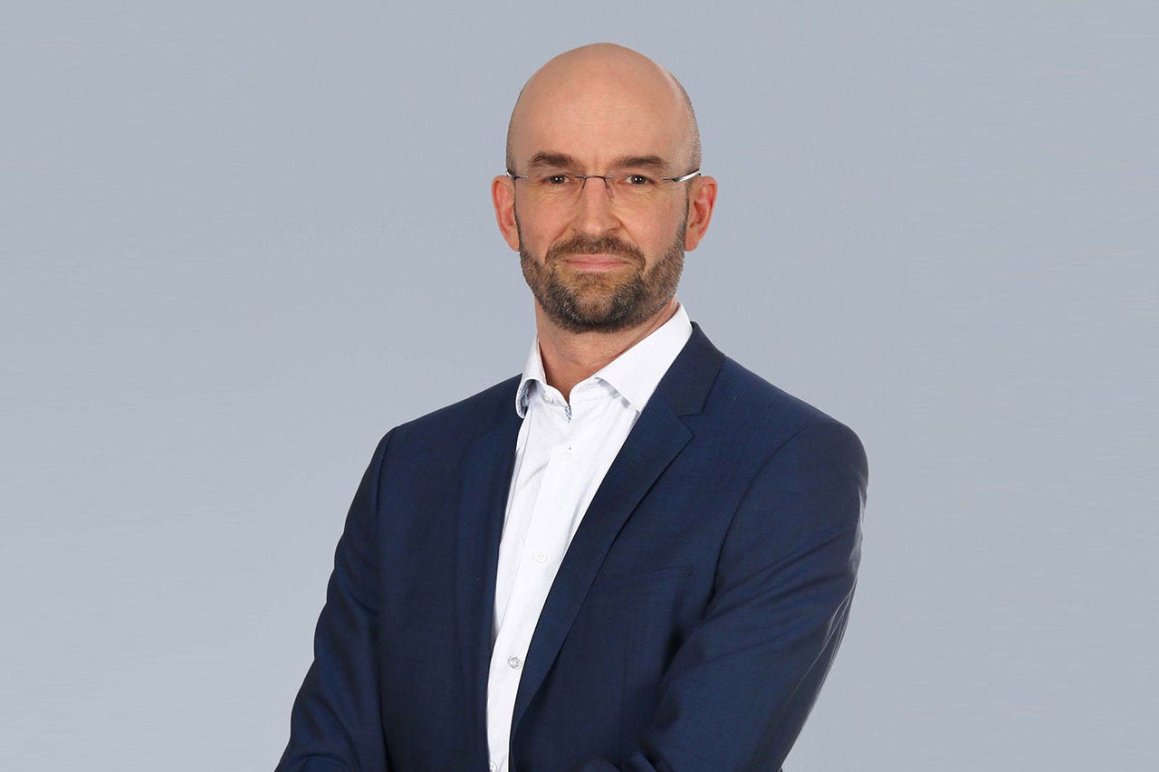 Porträt von Stefan Papst vor einem hellgrauen Hintergrund