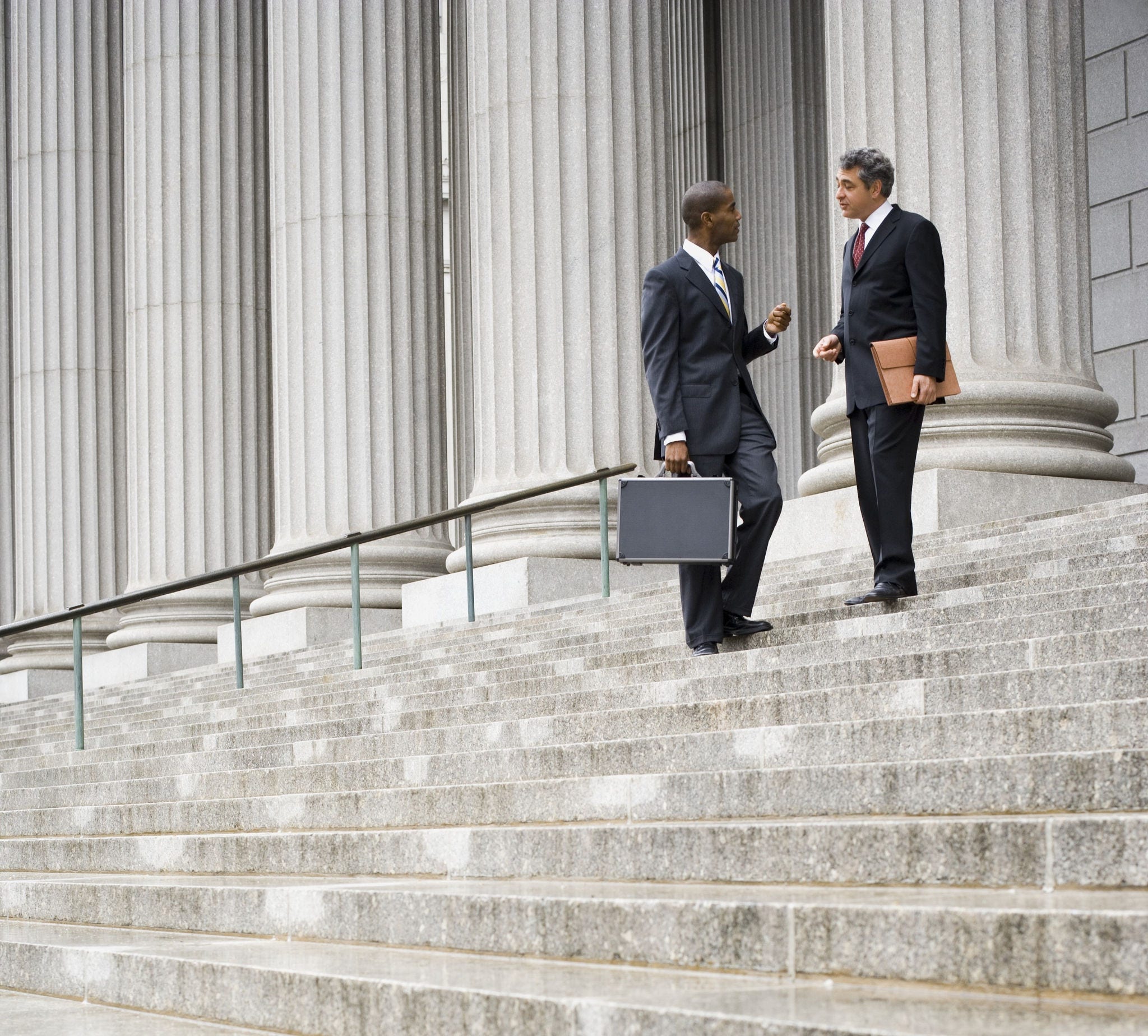 Low angle view of two men standing on the steps of a courthouse