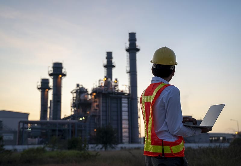 Service engineer working at an electric power plant with laptop