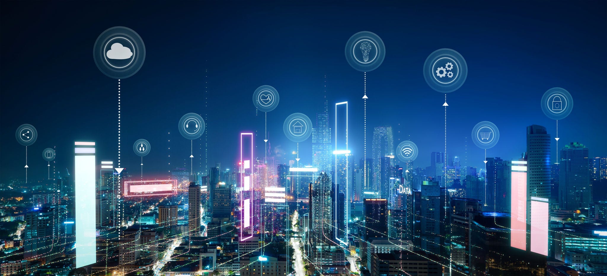 The city at night is bustling with activity, illuminated by the glow of countless IOT icons hovering in the sky. Smart city concept
