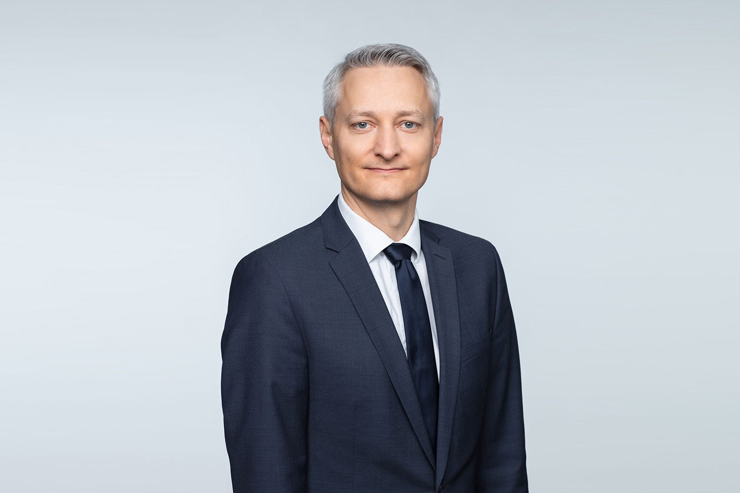 Porträt von Georg Gottholmseder vor einem hellgrauen Hintergrund