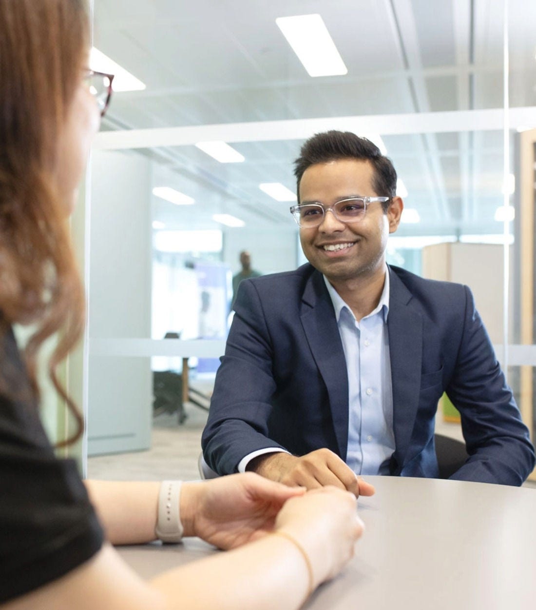 Two people with their hands on a table within an office space