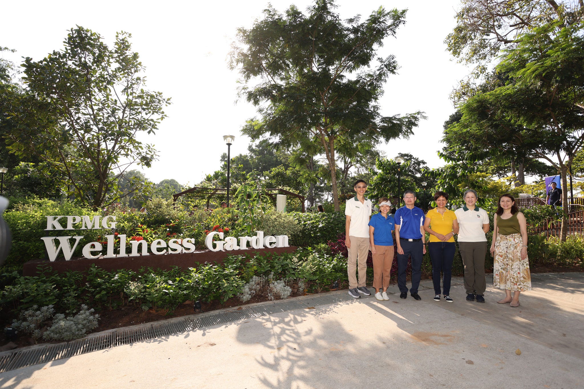 Group photo of Managing Partner Ong Pang Thye, Minister Indranee Rajah, and NParks representatives at the KPMG Wellness Garden main entrance signage