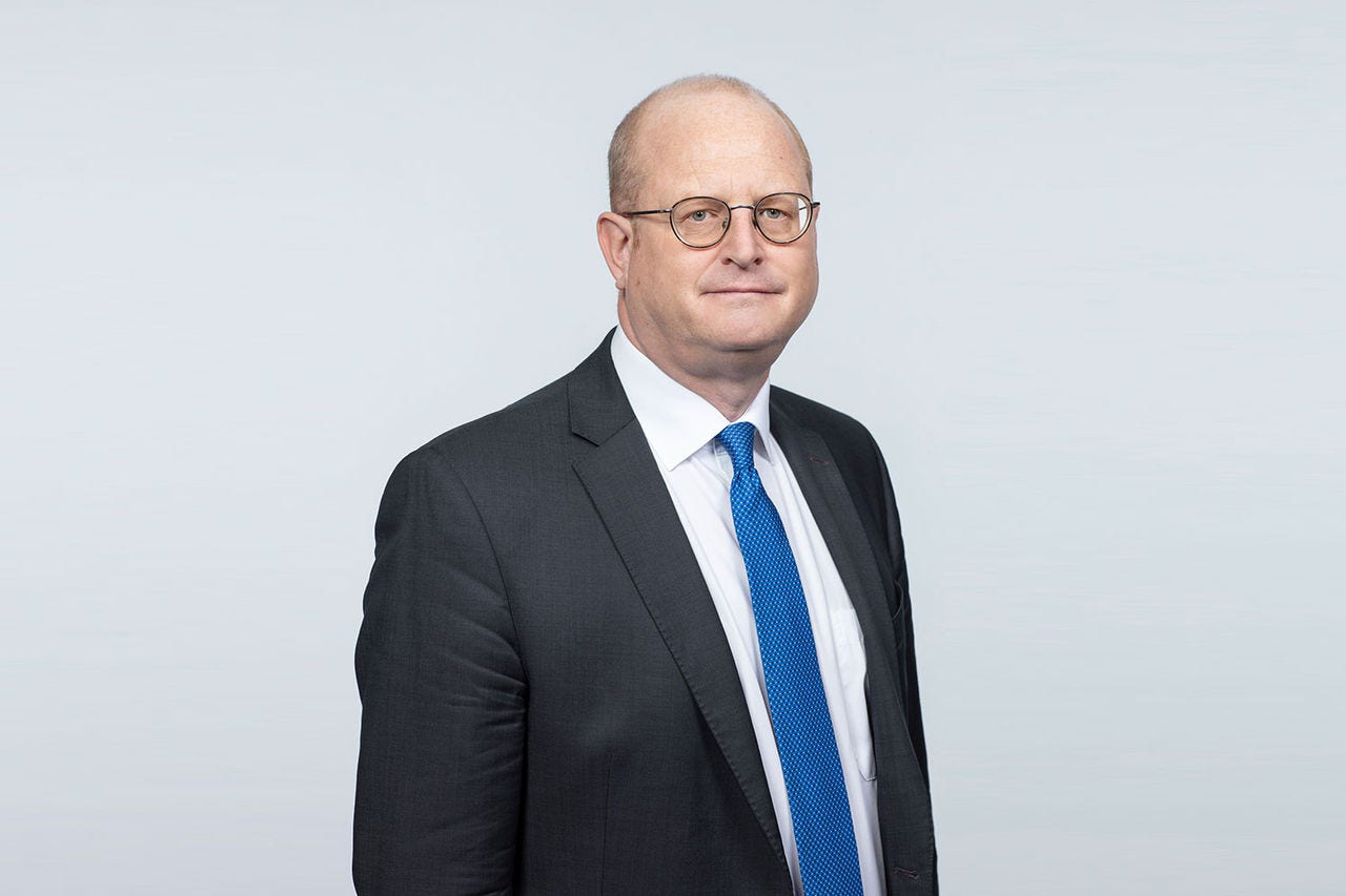 Porträt von Christoph Plott vor einem hellgrauen Hintergrund