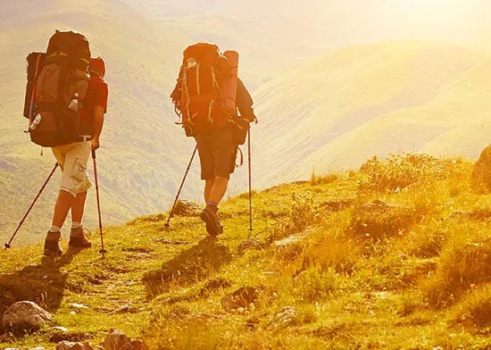 Two hikers in sunny hills
