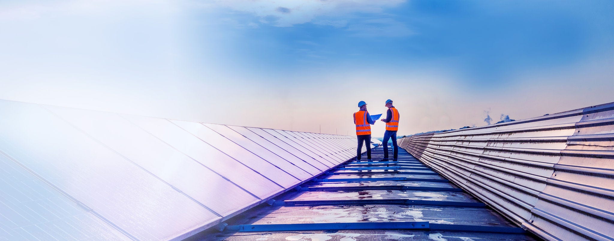Two technicians assessing rooftop solar panels