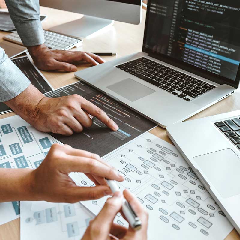 Two people working on laptop and documents