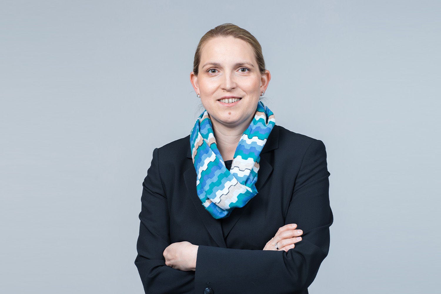 Porträt von Christiane Bischoff vor einer hellgrauen Wand
