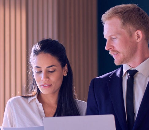 Two people in office collaborating on document