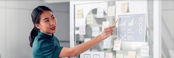 People looking at data on a transparent whiteboard