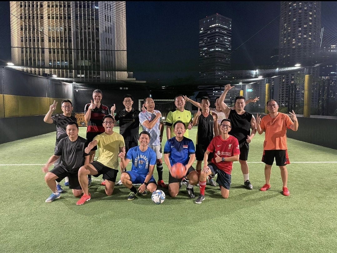 Group shot of Tang Chek Keng with former colleagues at regular after-work football sessions