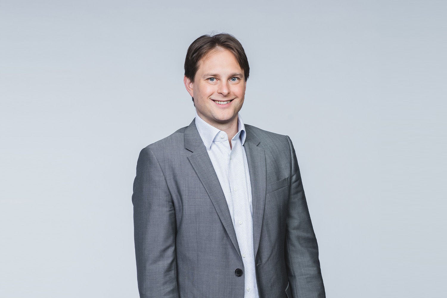 Porträt von Michael Petritz vor einem hellgrauen Hintergrund