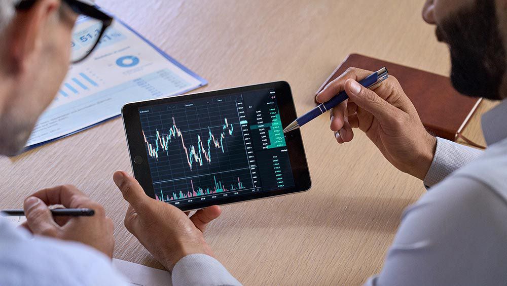 2 analysts looking at a graph on a tablet