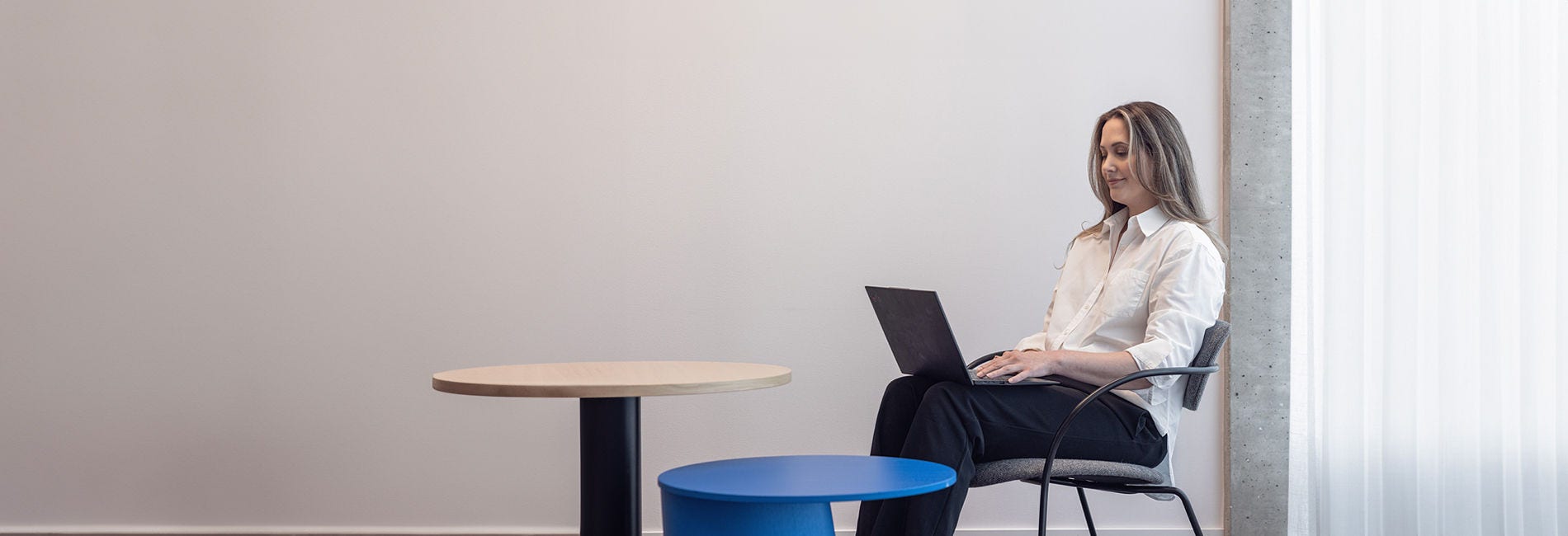 A businesswoman sitting on a chair and working with a computer