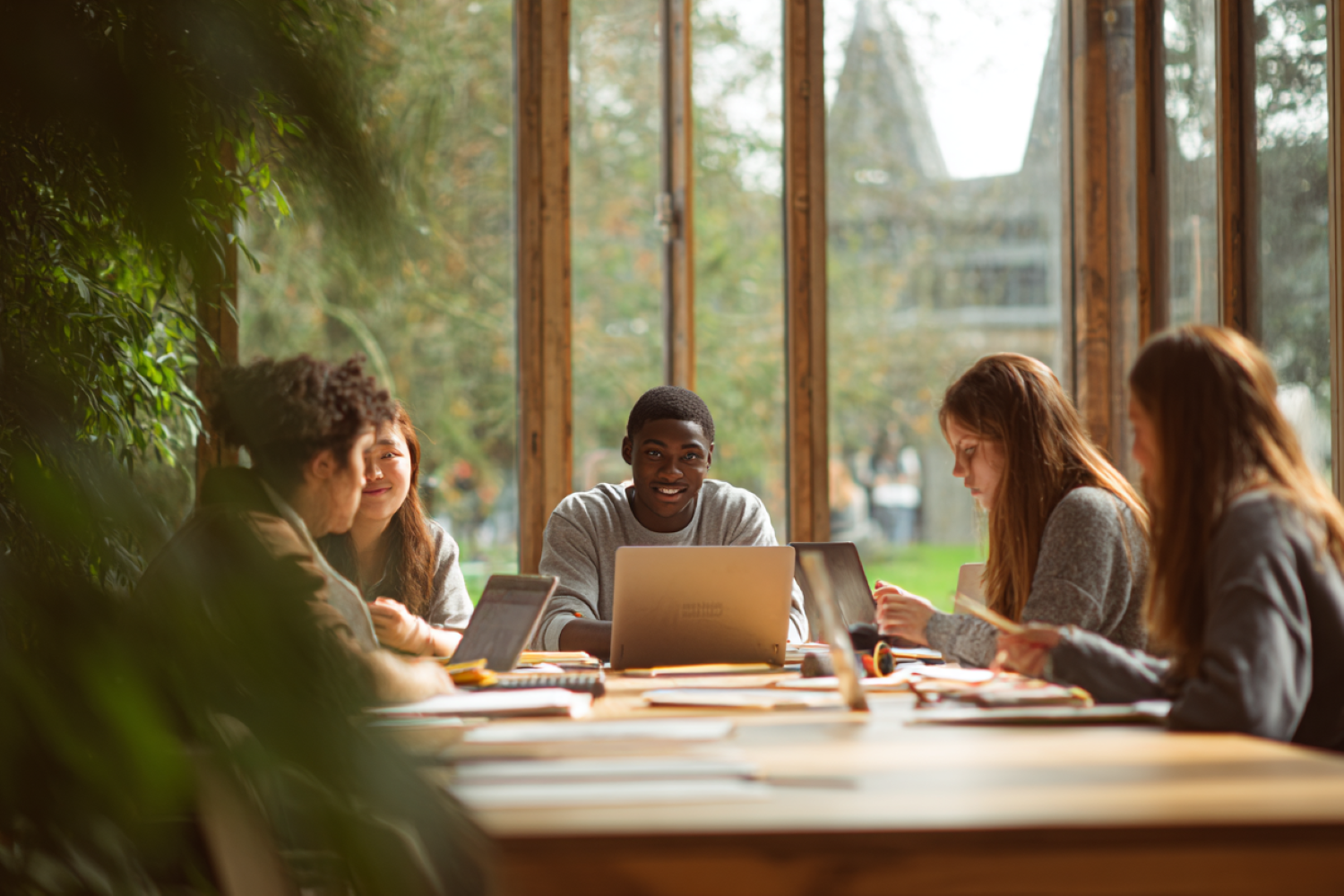 students at a table with laptops and books