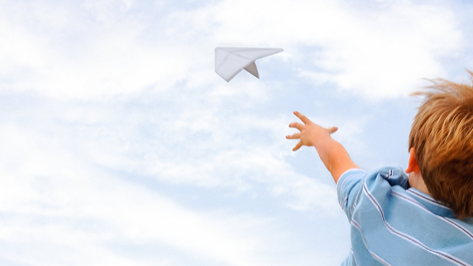 boy flying a paper airplane