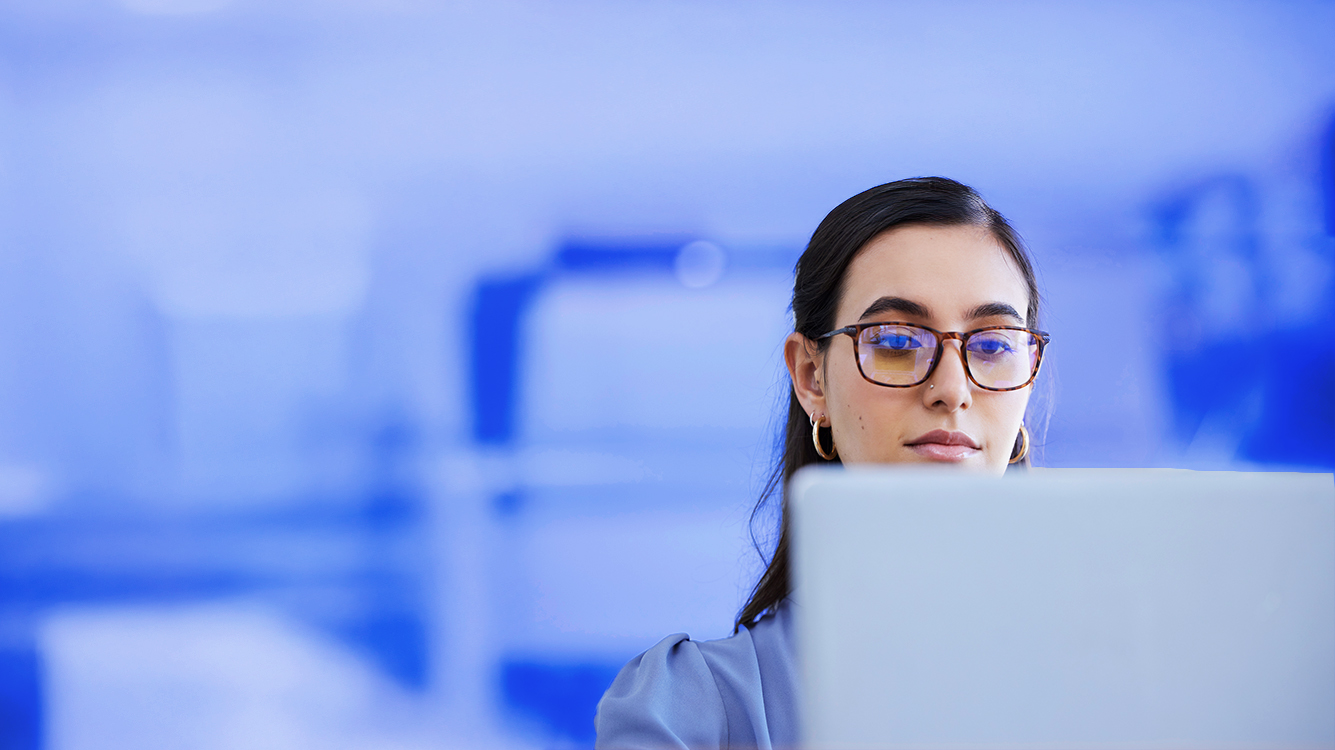 A person wearing glasses and looking at a computer screen