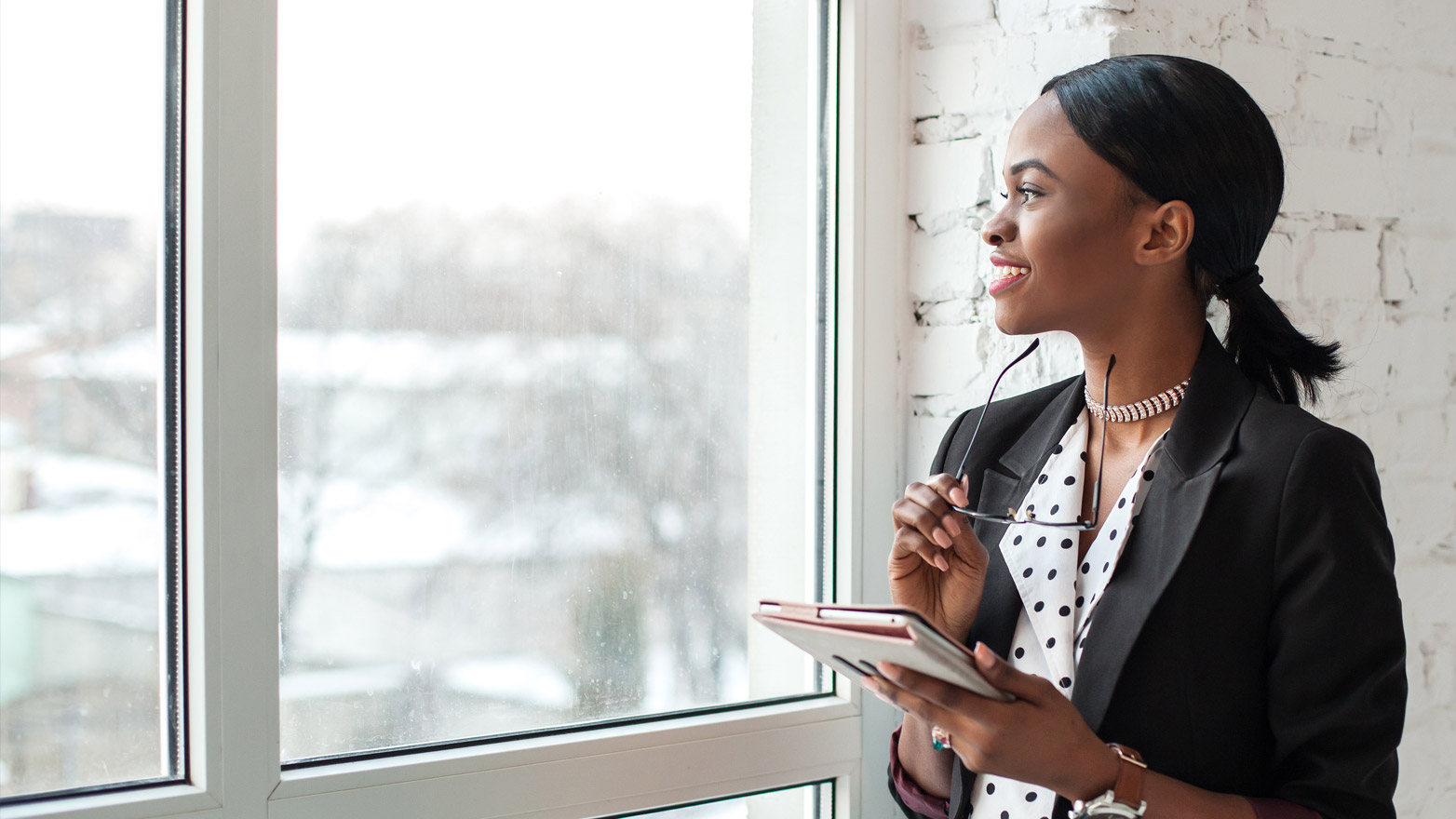 woman in front of a window working on her tablet