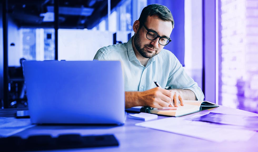 man at a desk in front of laptop