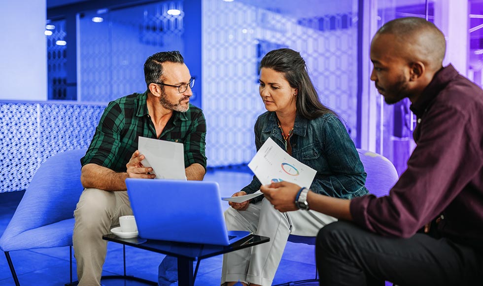 three people sitting down having a discussion about finance