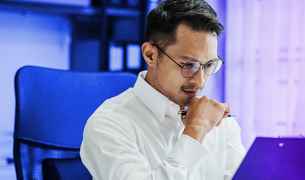 man looking at laptop screen with interest